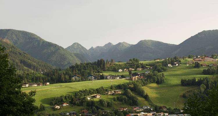 Paysage pittoresque avec des montagnes et des champs verdoyants.