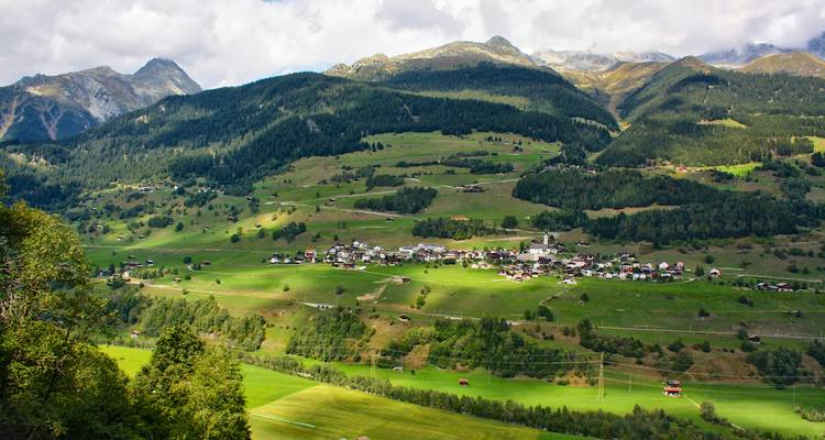 Vallée pittoresque avec un petit village entouré de montagnes.