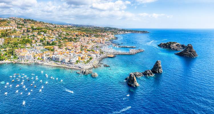 Vue aérienne d'une ville côtière avec des formations rocheuses.