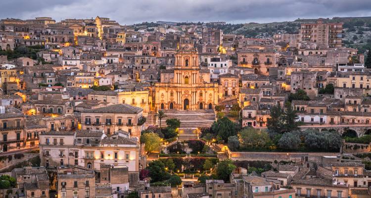 Paysage urbain historique illuminé au crépuscule.