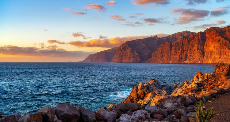 Cliffs and ocean at sunset with vibrant colors.