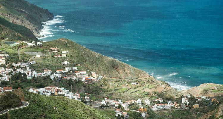 Coastal village with mountains and ocean.