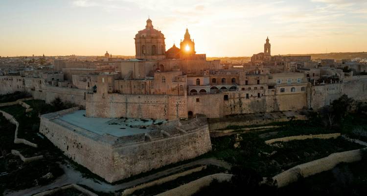 Historisch stadsbeeld bij zonsondergang met prominente kathedralen.