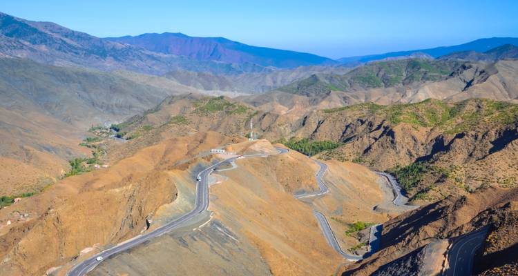 Kurvenreiche Bergstraße mit umliegendem felsigem Gelände.