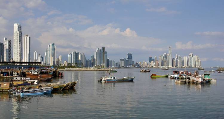 Moderne skyline van Panama-Stad met hoogbouw weerspiegeld in kalme baaiwateren en vissersboten op de voorgrond