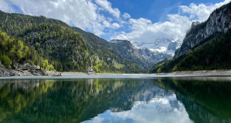 Prachtig meer omringd door bergen met besneeuwde toppen weerspiegeld in het water.