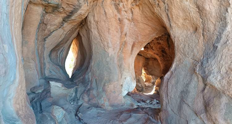 Natural rock formations with light streaming through openings.