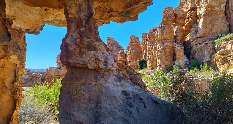 Rocky landscape with towering formations and blue sky.