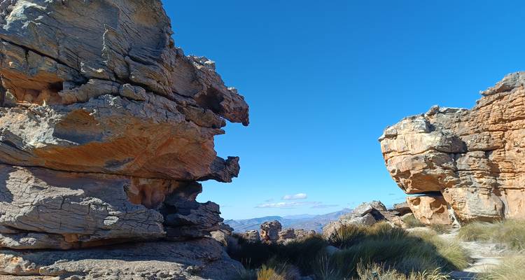 Rugged rock formations beneath a bright blue sky.