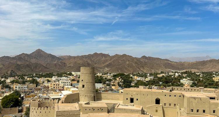 Een fort met een ronde toren te midden van een woestijnlandschap met bergen in de verte.
