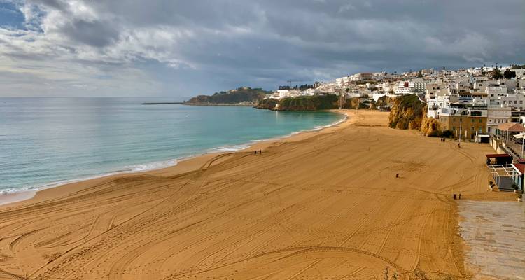 Plage de sable doré et ville côtière.