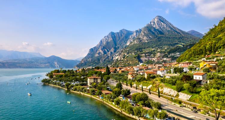Ville pittoresque au bord du lac avec des montagnes en arrière-plan.
