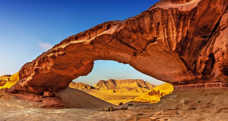 Arche rocheuse naturelle dans le paysage désertique du Wadi Rum.