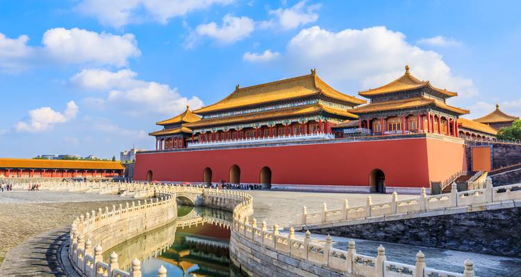 The Forbidden City with a canal and clear blue sky.