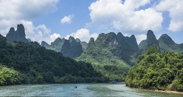 Karst mountains and a river under a blue sky.