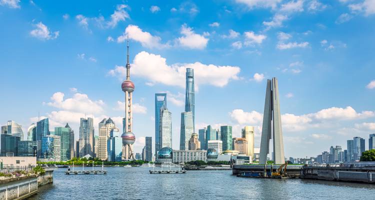 Shanghai skyline with modern skyscrapers and a river in the foreground.