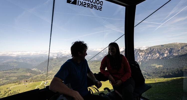 People inside a gondola taking in the scenic mountain view.