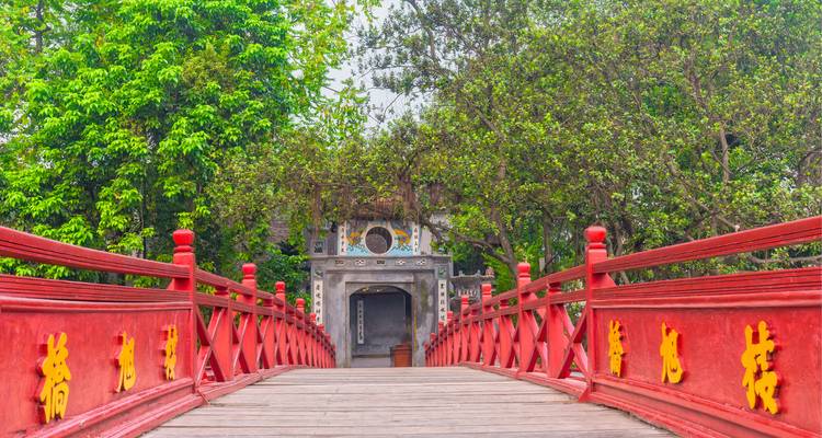 Bunte Brücke, die zu einem traditionellen Architekturbauwerk führt.