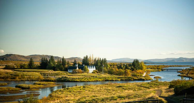 Malerische Aussicht auf eine Kirche und Grünflächen in der Nähe eines Sees.