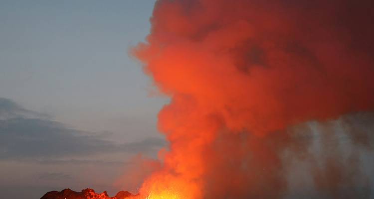 Ausbrechender Vulkan mit glühender Lava und aufsteigendem Rauch.