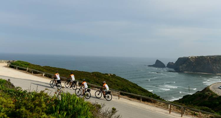 Cyclistes roulant sur une route côtière pittoresque.