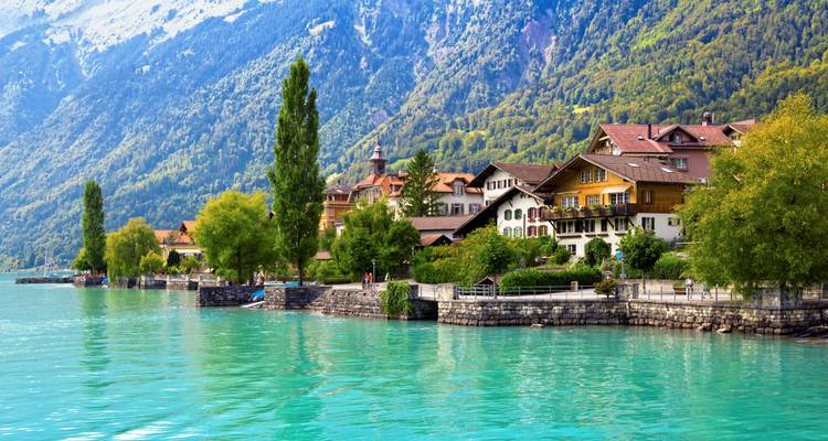 Lakeside village with a backdrop of lush mountains.