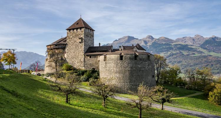 Castillo histórico con montañas al fondo.