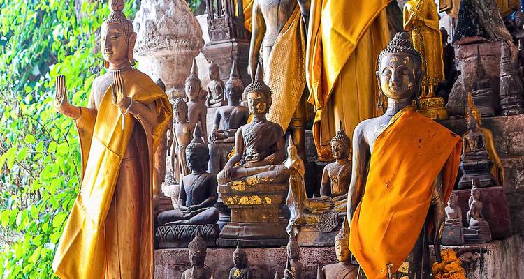 Diverses statues bouddhistes drapées de tissu doré.
