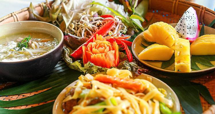 Repas vietnamien traditionnel avec divers plats colorés.
