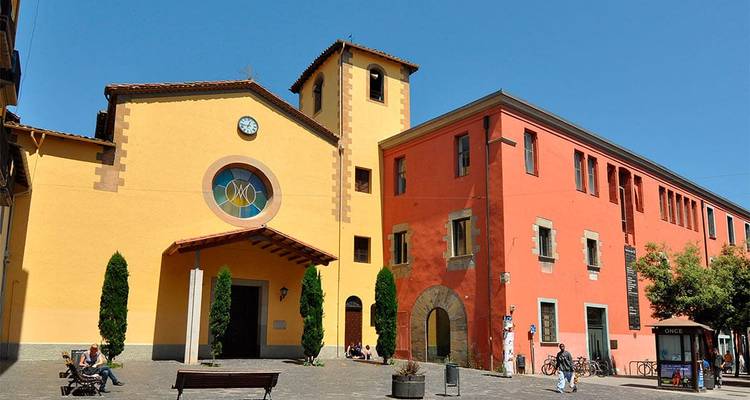 Colorful buildings and a small plaza with people relaxing.