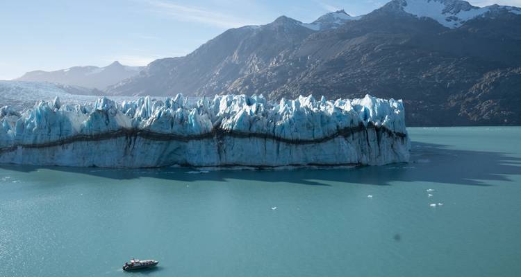 Großer Gletscher mit einem Boot im Wasser.