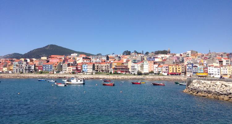 Ville côtière colorée avec des bateaux de pêche amarrés dans le port.
