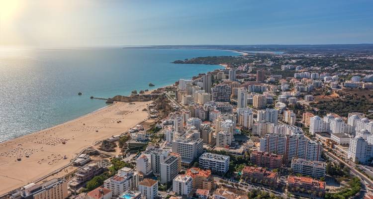 Vue aérienne d'un littoral avec des immeubles de grande hauteur et une plage.