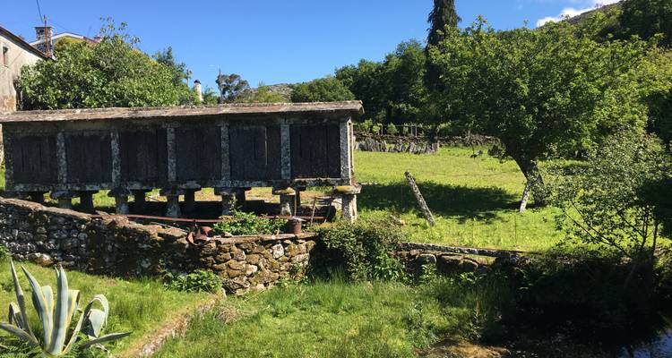 A traditional granary structure in a green meadow.