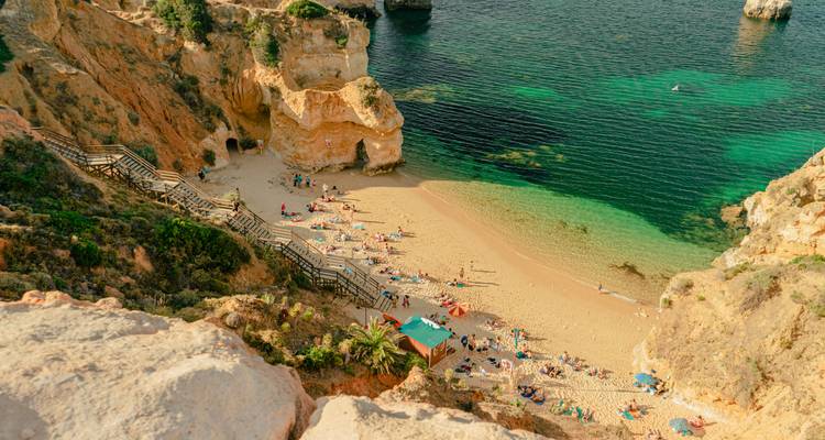 Vue aérienne d'une plage bondée aux eaux claires.