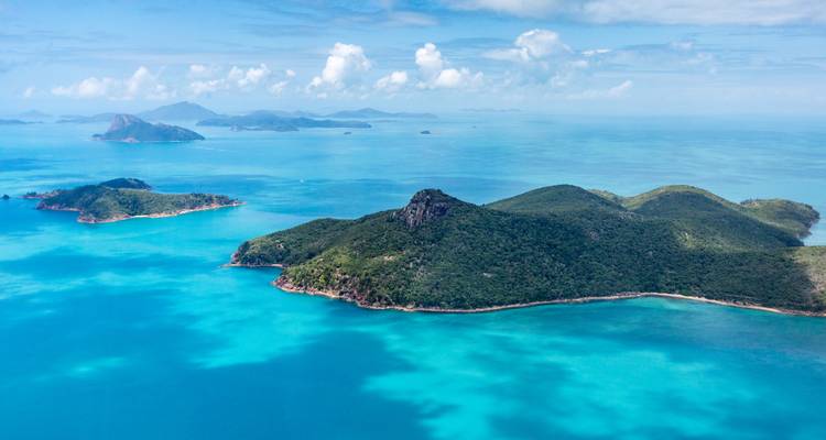 Vue d'îles verdoyantes entourées d'eaux océaniques turquoise.