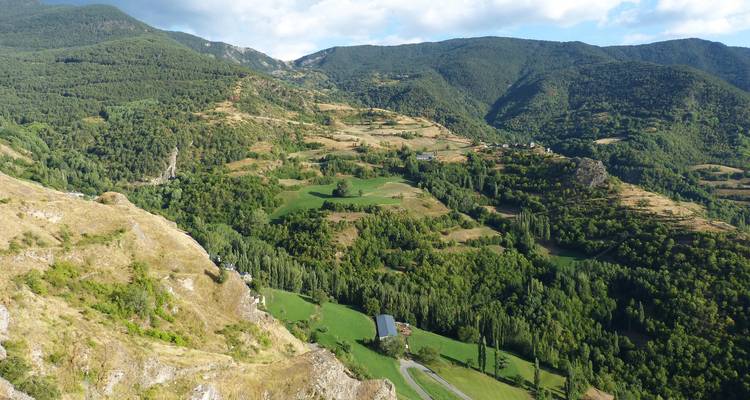 Vue aérienne d'un paysage montagneux rural avec de la verdure.