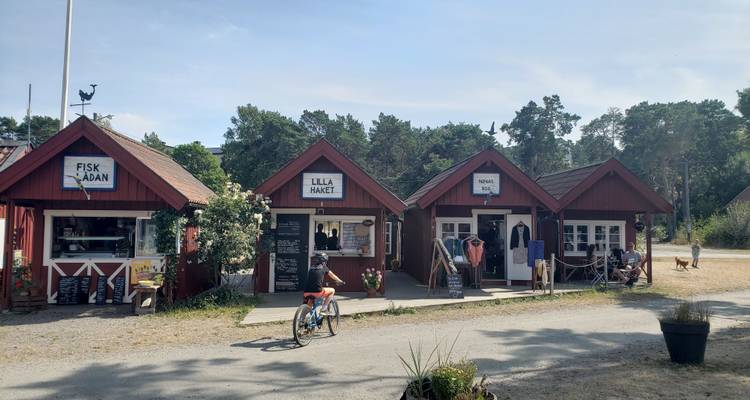 Quaint market area with red huts under a partly cloudy sky.