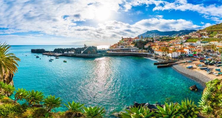 Un pueblo costero colorido con una vista clara de aguas turquesas.