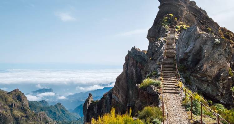 Trap die naar een rotsachtige piek boven de wolken leidt