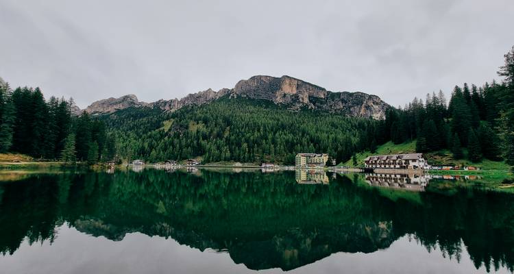 Calm lake reflecting mountains and forest.