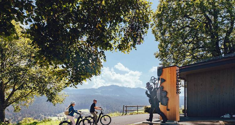 Zwei Radfahrer, die kurz davor stehen, eine malerische Route mit schönen Hügeln und klarem Himmel zu beginnen.