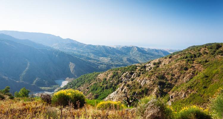 Una vista pintoresca de un valle verde y exuberante flanqueado por montañas y un río.