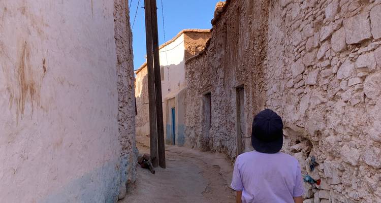 Narrow alleyway with rustic buildings and a person walking.