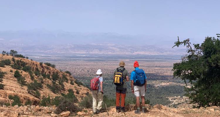 Group of hikers enjoying a panoramic view of a valley.