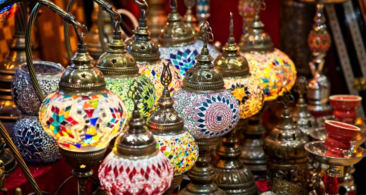 A vibrant and colorful display of traditional artisan lamps in a market.
