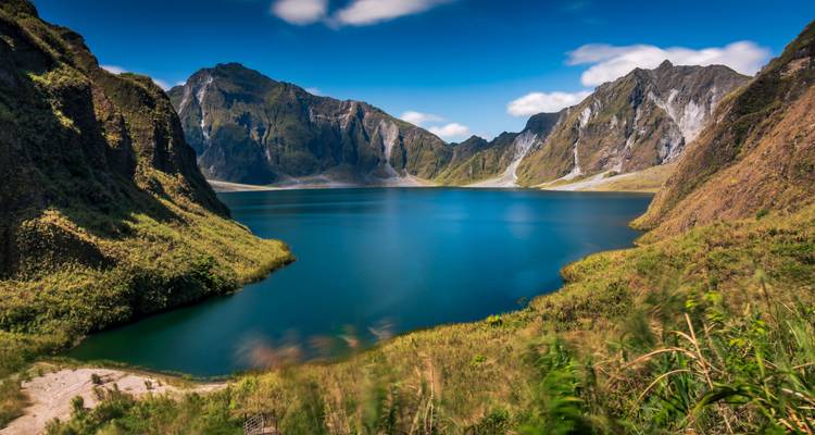 Ein ruhiger blauer See, umgeben von schroffen Bergen.
