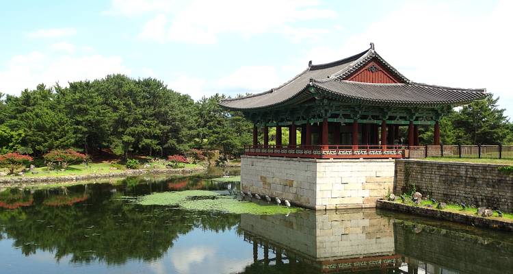 Traditional Korean pavilion by a reflective pond.