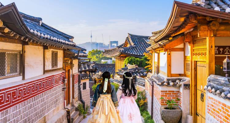 Women in traditional dress walking through a historical neighborhood.