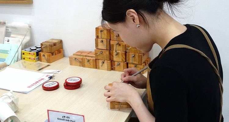 Woman working on traditional crafts at a table.